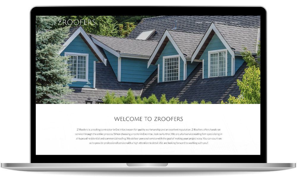 A laptop screen displaying the Z Roofers website, featuring an image of a house with blue siding and multiple gabled roofs. The site includes a welcome message from the company.