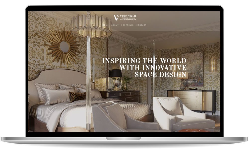 Laptop displaying a website homepage with a luxurious bedroom interior, featuring the text "Inspiring the world with innovative space design" in the center.